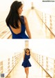 A woman in a blue dress walking on a pier.