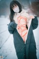 A woman wearing a face mask standing in the snow.