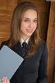 A woman in a business suit holding a folder.