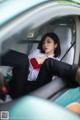 A woman sitting in the driver's seat of a car.