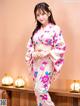 A woman in a pink kimono posing for a picture.