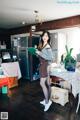 A woman standing in a kitchen holding a book.