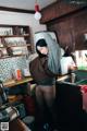 A woman standing in a kitchen next to a sink.